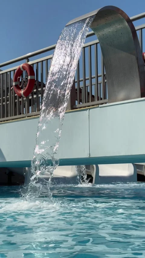 A relaxing waterfall cascading into an open-air spa pool surrounded by serene Stock Footage 301852534
