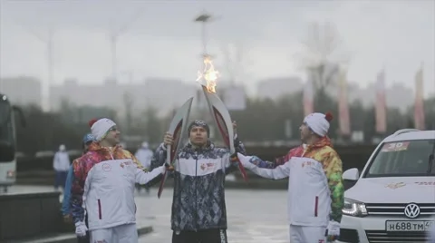 Relay race Sochi Olympic torch in Saint Petersburg. Male torchbearer pass flame Stock Footage 62744192
