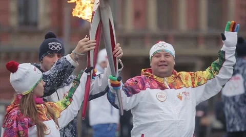 Relay race Sochi Olympic torch in Saint Petersburg. Two torchbearers hold flame Stock Footage 62745026