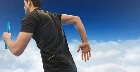 Relay runner against clouds and blue sky Foto stock