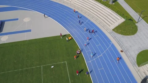Relay runners passing batons on track from above. Stock Footage 247241188