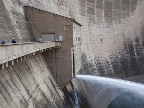Release of water and two workers at impressive Katse Dam hydroelectric power Stock Photos