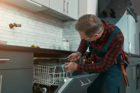 Reliable worker. Man solves household problems. Side view Stock Photos