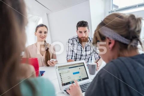 Reliable young co-workers thinking of solutions and successful ideas Stock Photos