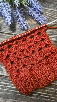 A relief openwork pattern knitted with colored yarn on a wooden background Stock Photos