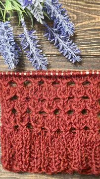 A relief openwork pattern knitted with colored yarn on a wooden background Photos