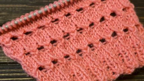 A relief openwork pattern knitted with colored yarn on a wooden background Stock Photos
