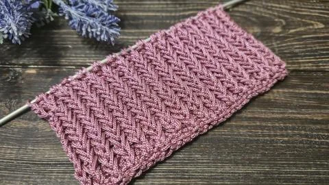 A relief openwork pattern knitted with colored yarn on a wooden background Stock Photos