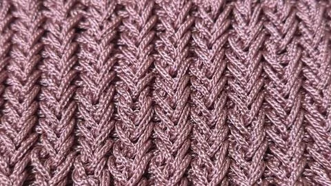 A relief openwork pattern knitted with colored yarn on a wooden background Stock Photos