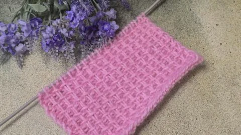 A relief openwork pattern knitted with colored yarn on a wooden background 写真素材