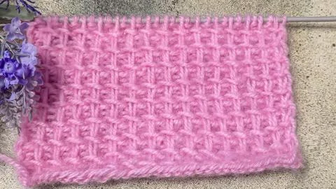 A relief openwork pattern knitted with colored yarn on a wooden background Stock Photos