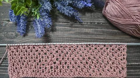 A relief openwork pattern knitted with colored yarn on a wooden background Fotos de archivo