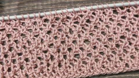 A relief openwork pattern knitted with colored yarn on a wooden background Stock Photos