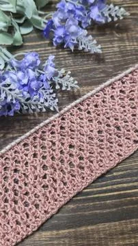 A relief openwork pattern knitted with colored yarn on a wooden background Stock Photos
