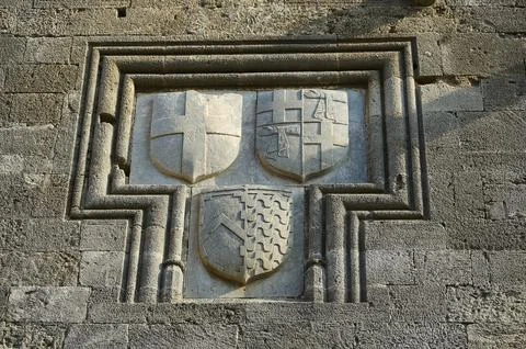 Relief with three coats of arms in a rectangular stone frame on a medieval wall, 写真素材