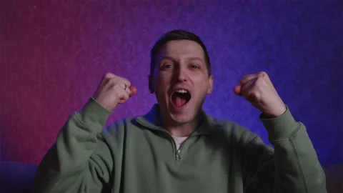 Relieved man celebrating win after intense sports moment Stock Footage 333757086