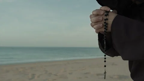 Religious Hands Of A Monk Praying Rosary On The Beach Stock Footage 274368341