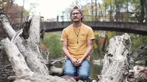 A religious man contemplates the Bible while outside in a park Stock Footage 142225290