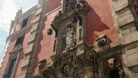 A religious statue on a historic red brick building facade in Madrid Spain Vídeos de archivo 323048792