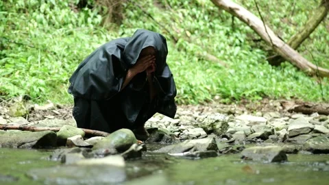 Religious wanderer uses a forest spring for rest during a long journey. Stock Footage 336696229