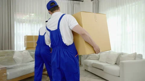 Relocation company employee is loading boxes or crates into a new home. Stock Footage 208966993