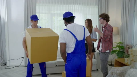 Relocation company employee is loading boxes or crates into a new home. Stock Footage 229483153