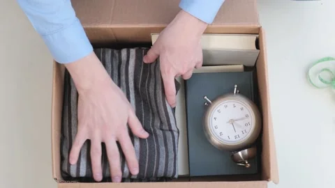 Relocation. A man puts things in a cardboard box when moving Stock Footage 169754047