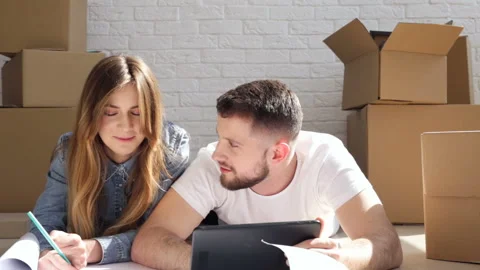 Relocation in to the new house. Happy couple are laughing. Stock Footage 88100596