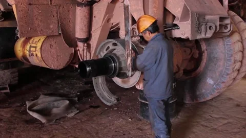 Rem 029An auto mechanic does his job, repairs a huge quarry dump truck. Stock Footage 124576597
