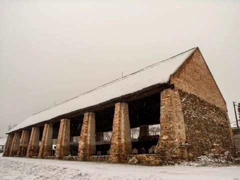 Remains of an old peaked building made of bricks in the falling snow.   Stock Photos