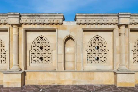 Remarkable stone latticework and arches against a clear blue sky, reflecting Stock Photos