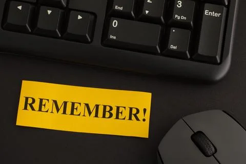 Remember! A paper note with the word Remember on it on a desk Stock Photos