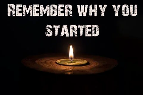 Remember why you started - white candle with dark background - in a wooden .. Stock Photos
