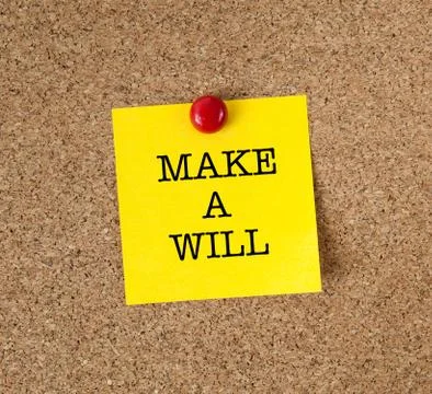 A reminder to Make A Will in red text on a yellow sticky note posted on cork Stock Photos