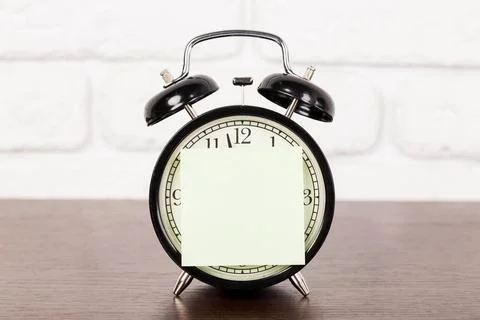 Reminder note and black old-fashioned alarm clock Stockfoto's