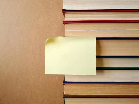 Reminder note stuck to a stack of books Stock Photos