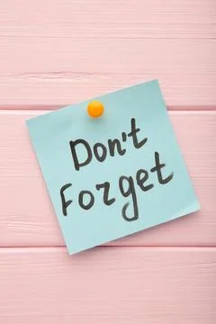 Reminder with text 'Don't forget' on a blue memo on pink background Stock Photos