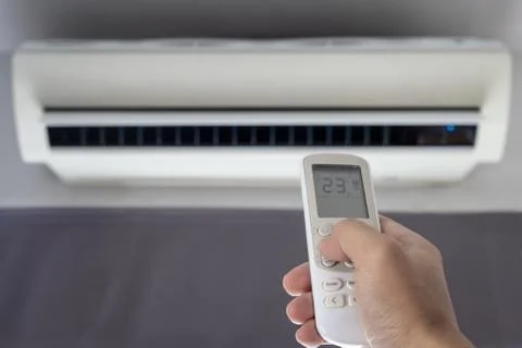Remote air condition on hand, save power concept Stock Photos