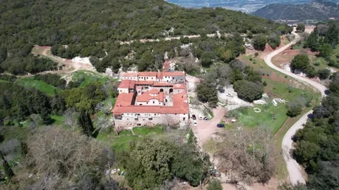 Remote Byzantine monastery emerging within dense mountain forest landscape Stock Footage 344096337