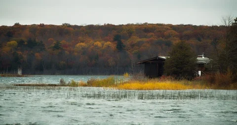Remote cabin on the edge of a lake during a wind storm 스톡 동영상 120621842