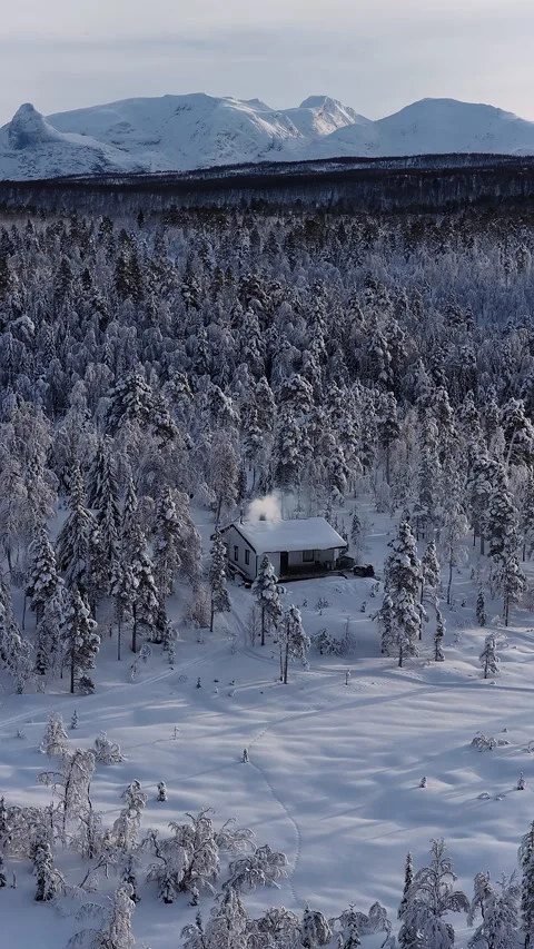 Remote cabin in snowy forest mountain landscape, Norway Видео 345968780