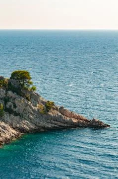 Remote cap with pine trees and visible horizon in Adriatic sea Stock Photos