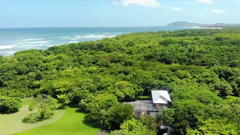 Remote construction site with metallic building in green countryside, sea coast Stock Footage 154836119
