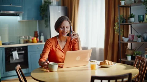 Remote consultant speaking smartphone sitting at kitchen with coffee cup closeup Stock Footage 333776013