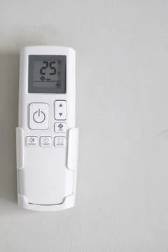 Remote control of air conditioner at the wall with copy space Stock Photos