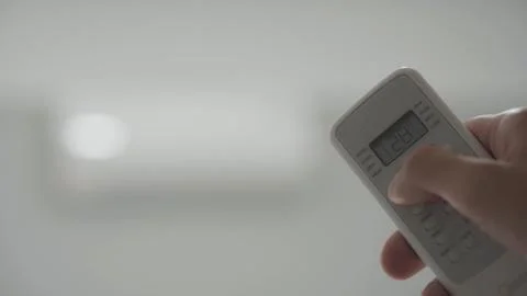 Remote control of the air conditioner when the room is hot Stock Photos