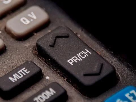 A remote control with channel and function buttons show signs of age and us.. Stock Photos