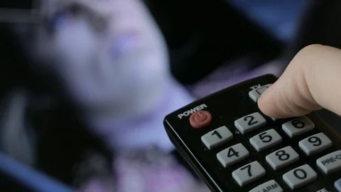 Remote control of channels on the TV Stock Footage 89877210