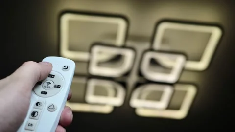 Remote control that controls the light. Neon chandelier on the ceiling. Stock Footage 191921152