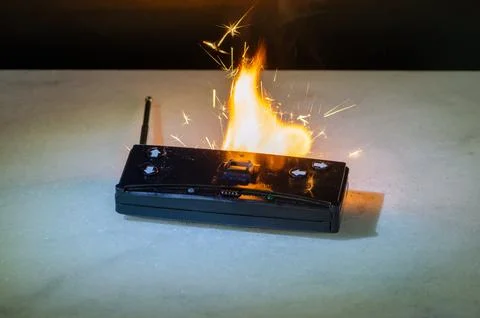 Remote control device burning on surface with flame as danger and risk concep Stockfoto's